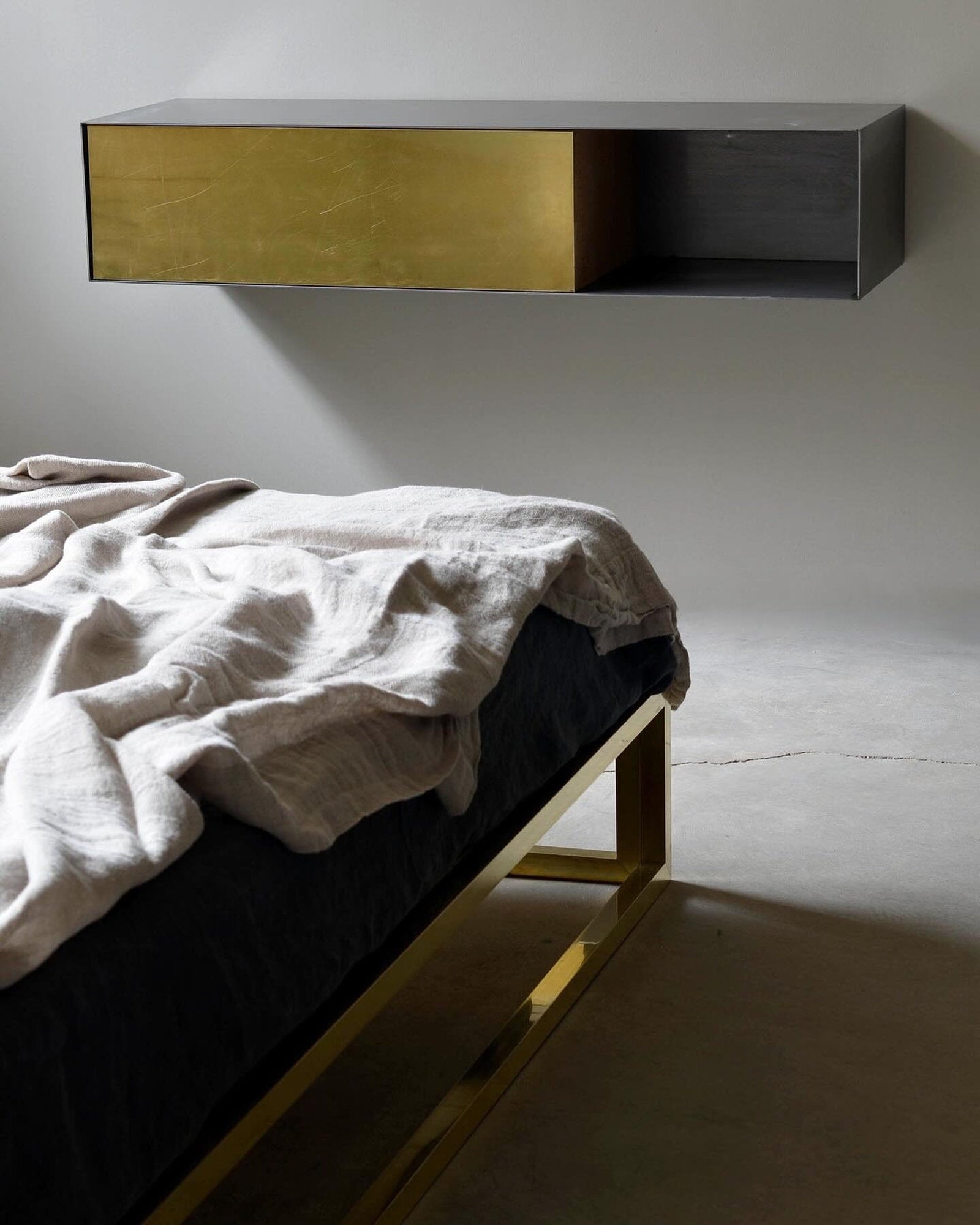 Mensola in metallo ed ottone con cassetto ribaltabile di Xam in camera da letto moderna