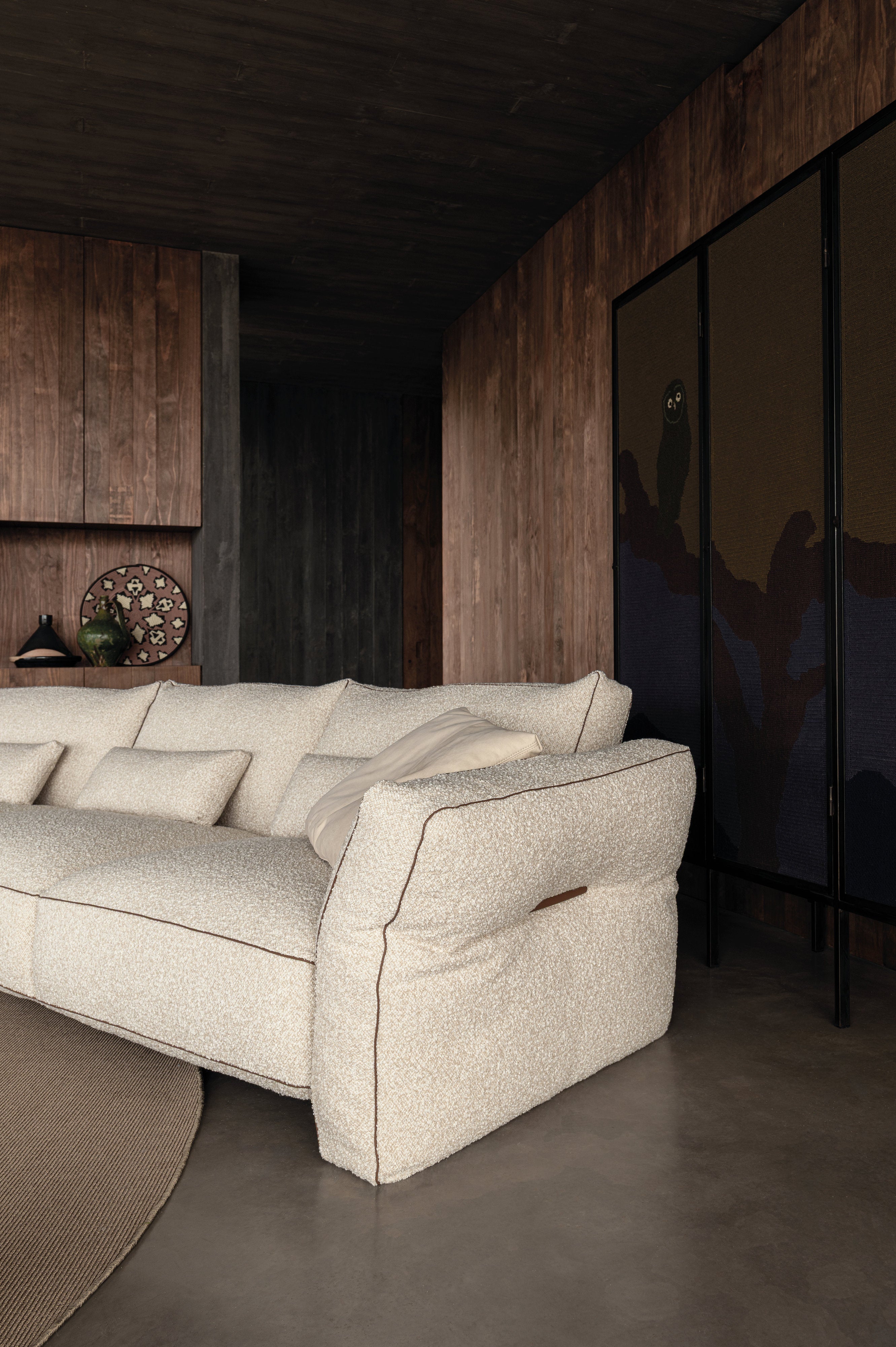 Particolare del bracciolo imbottito del divano Loden Cierre1972 in tessuto bouclé chiaro, cuciture evidenti e curve morbide