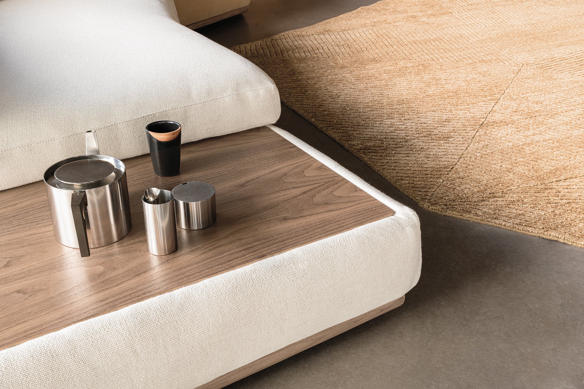 Dettaglio del tavolino integrato nel divano Montgomery, finitura Noce Canaletto