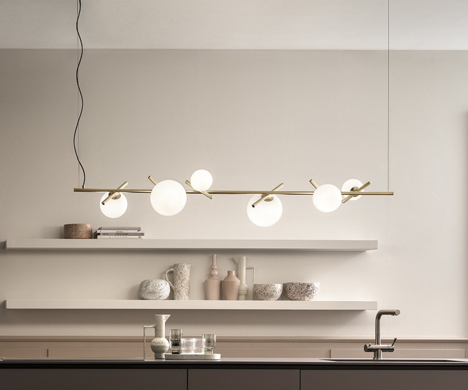 Lampada a sospensione con struttura in ottone e diffusori in vetro opalino in cucina moderna