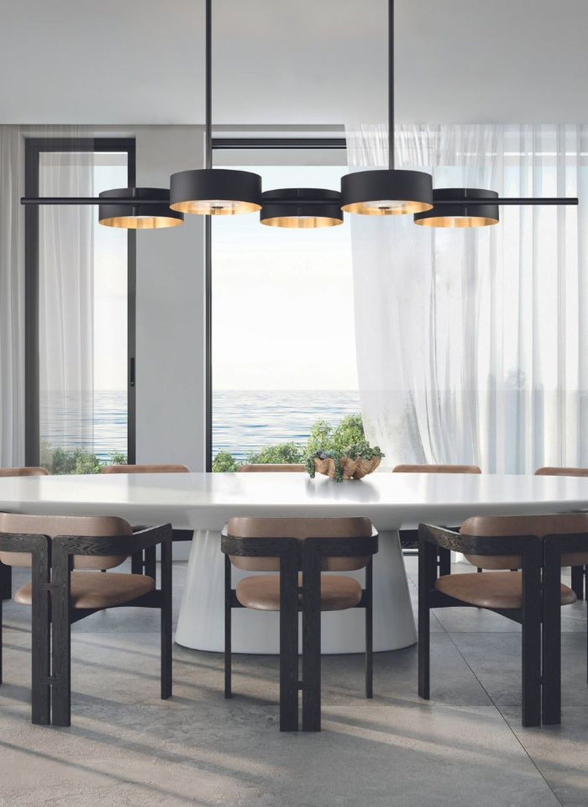 Sospensione lineare Sound BIL5 di Masiero a 5 luci, installata sopra un tavolo da pranzo ovale in un soggiorno vista mare.