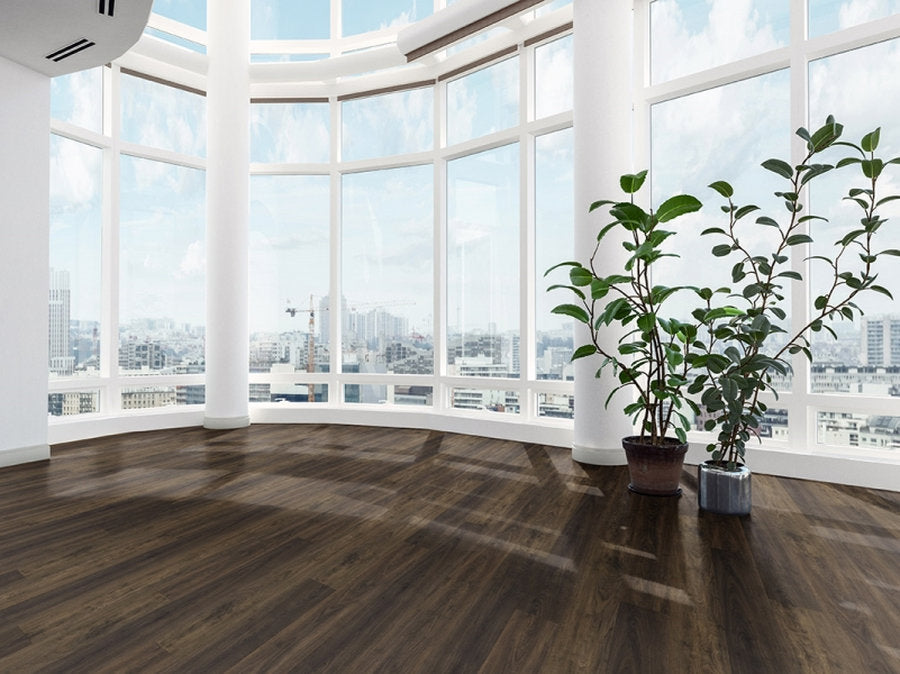 Interno con pavimento SPC Skema StarK finitura Bilbao, tonalità marrone scuro e doga lunga in ambiente luminoso