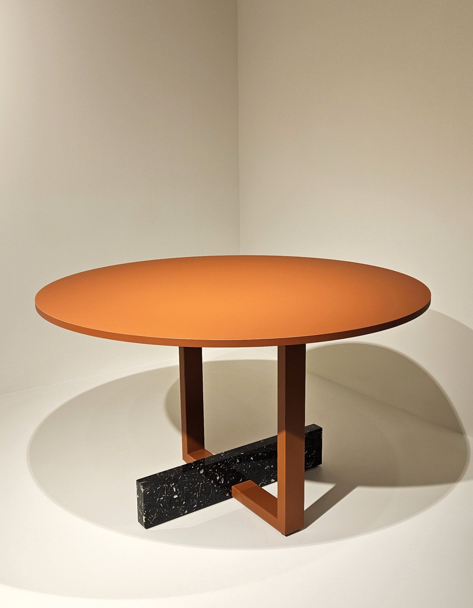 Tavolo Pied-à-Terre di Magis in versione rotonda fissa, struttura in acciaio verniciato rosso mattone e base con zavorra in marmo