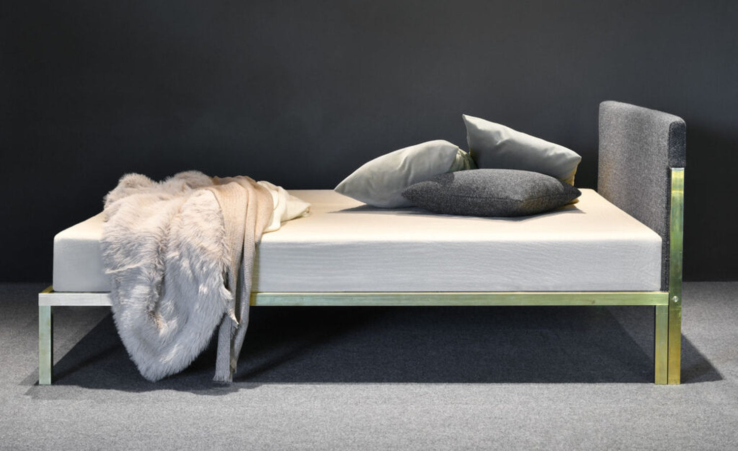 Letto design minimal di Xam con struttura in ottone e testata imbottita in tessuto
