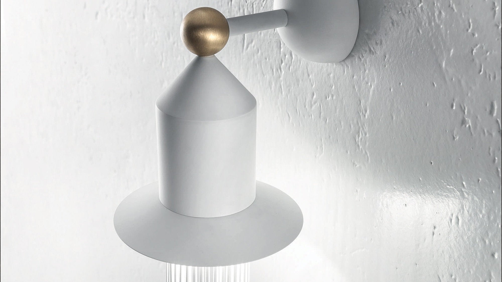 Dettaglio cappello applique Nappe Masiero in bianco e oro su parete materica bianca