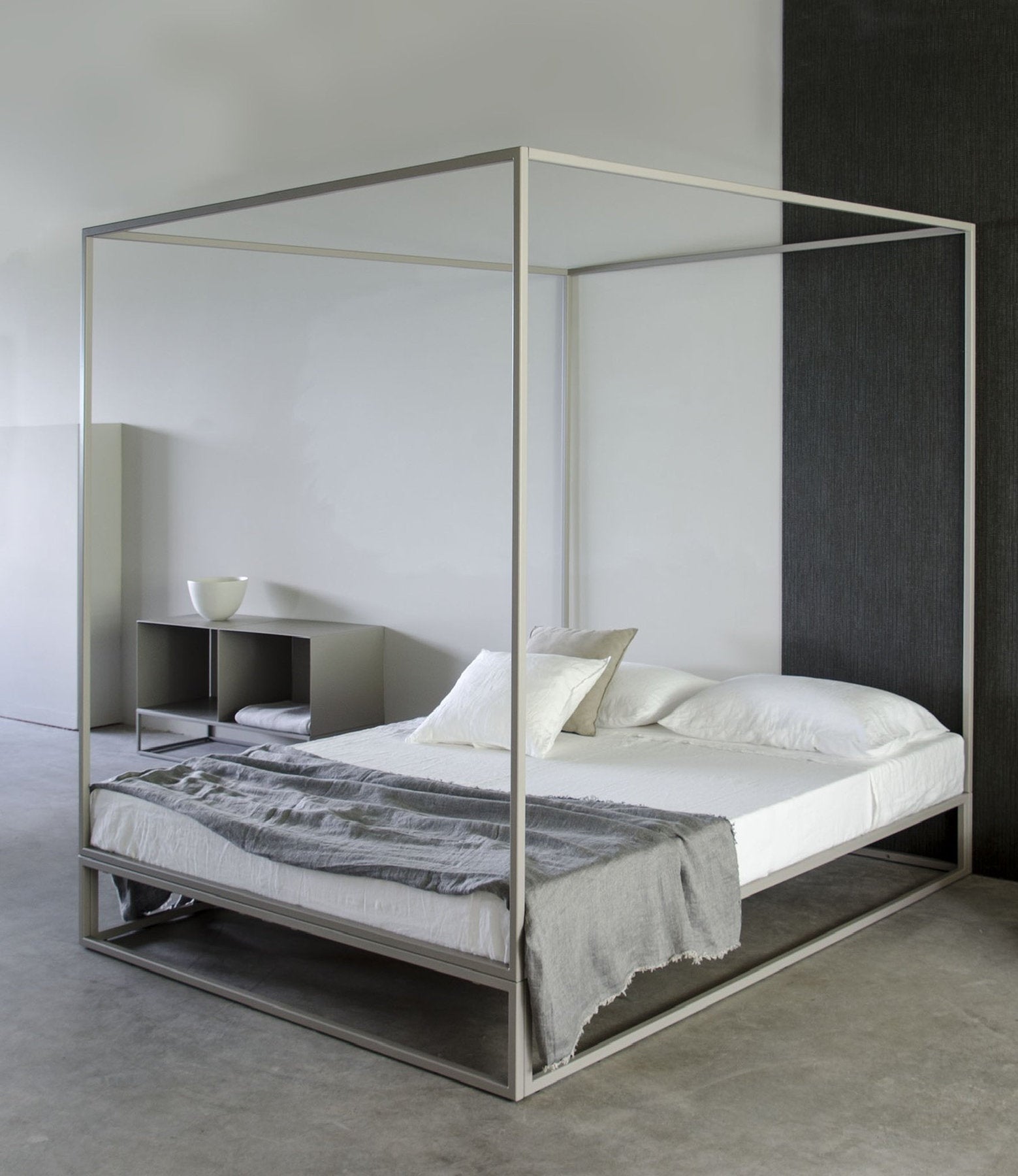Letto Xam Asha a baldacchino in metallo chiaro con biancheria bianca e plaid grigio, ambiente moderno con fondo grigio