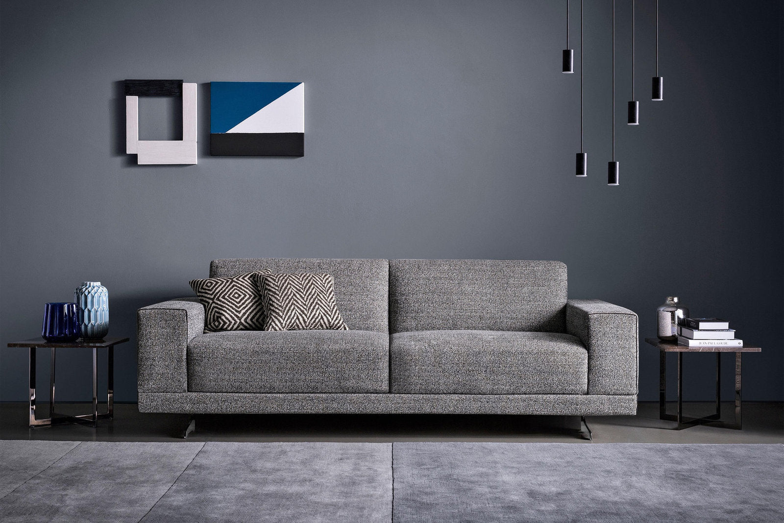 Divano letto componibile Jimmy in tessuto grigio, ambientato in un soggiorno contemporaneo