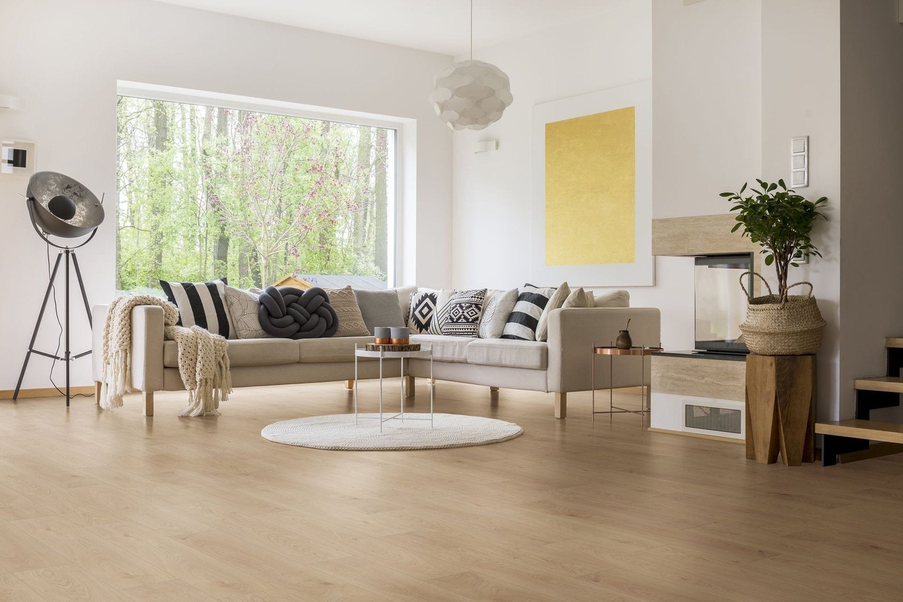 Soggiorno luminoso con ampie vetrate, arredi chiari e pavimento in laminato effetto rovere chiaro Skema Facile+