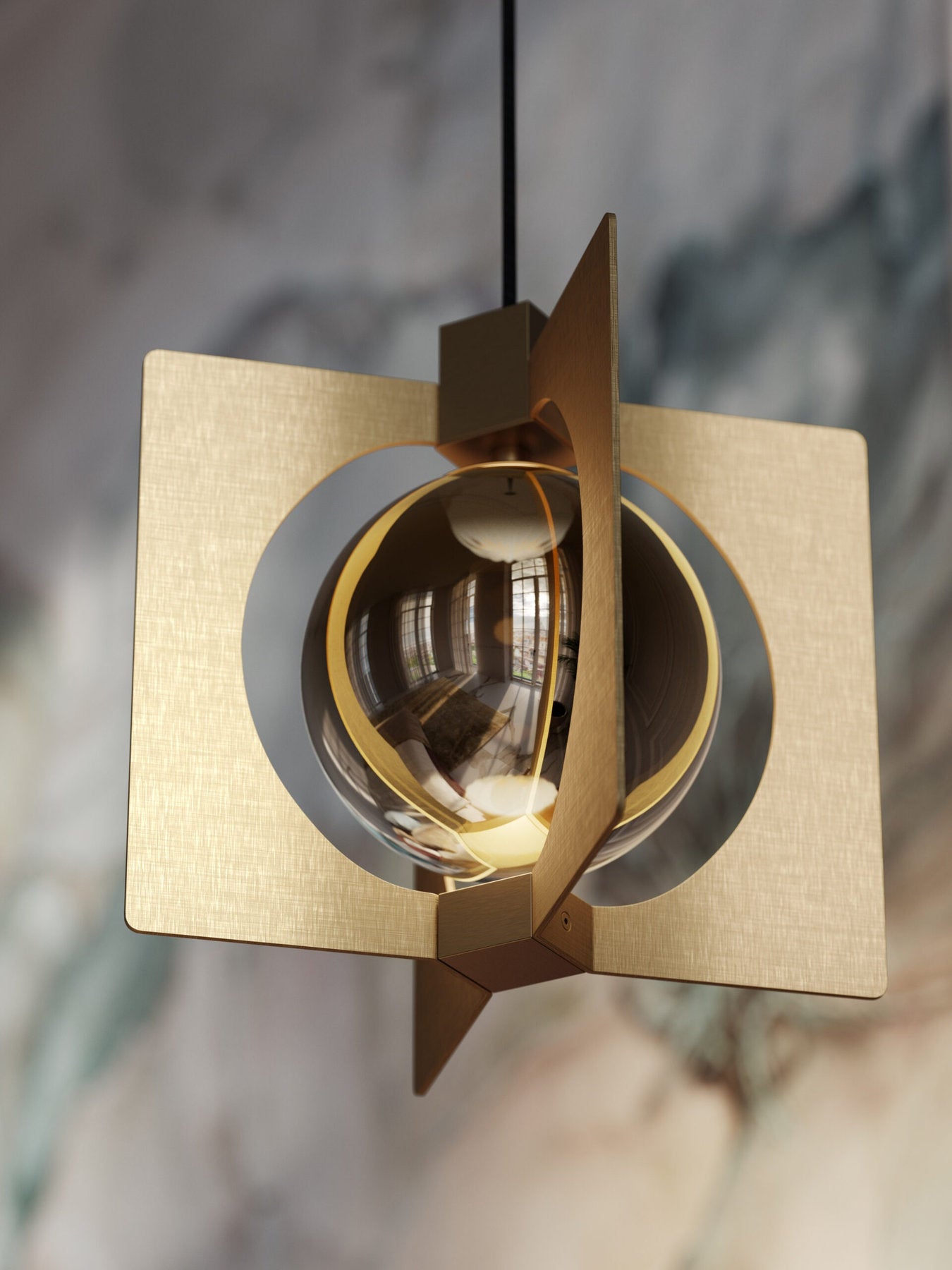 Dettaglio lampada Girouette Masiero con sfera dorata e lamine metalliche su sfondo marmorizzato