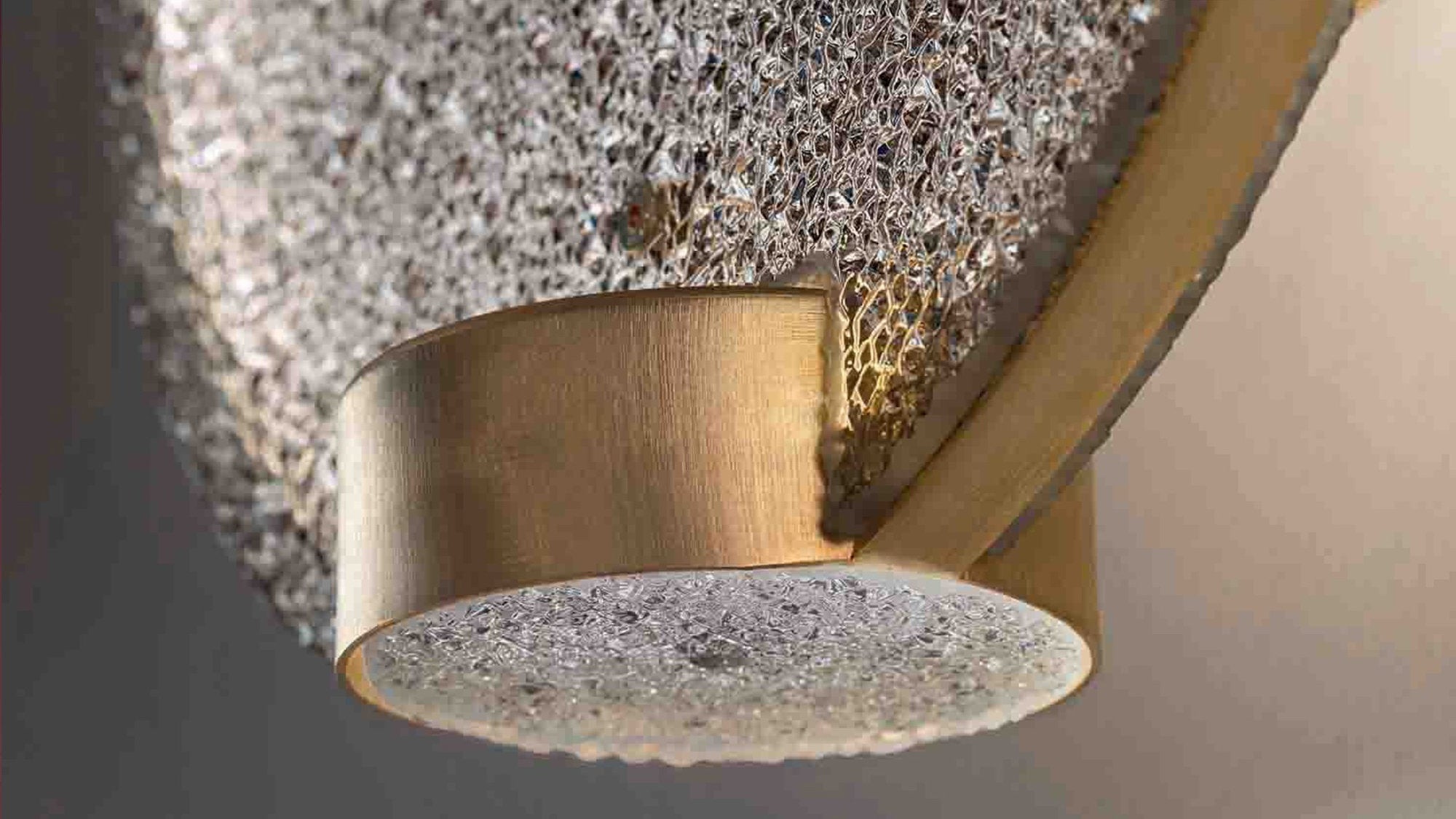 Dettaglio del diffusore in vetro prismatico e ottone della lampada a LED Horo by Masiero
