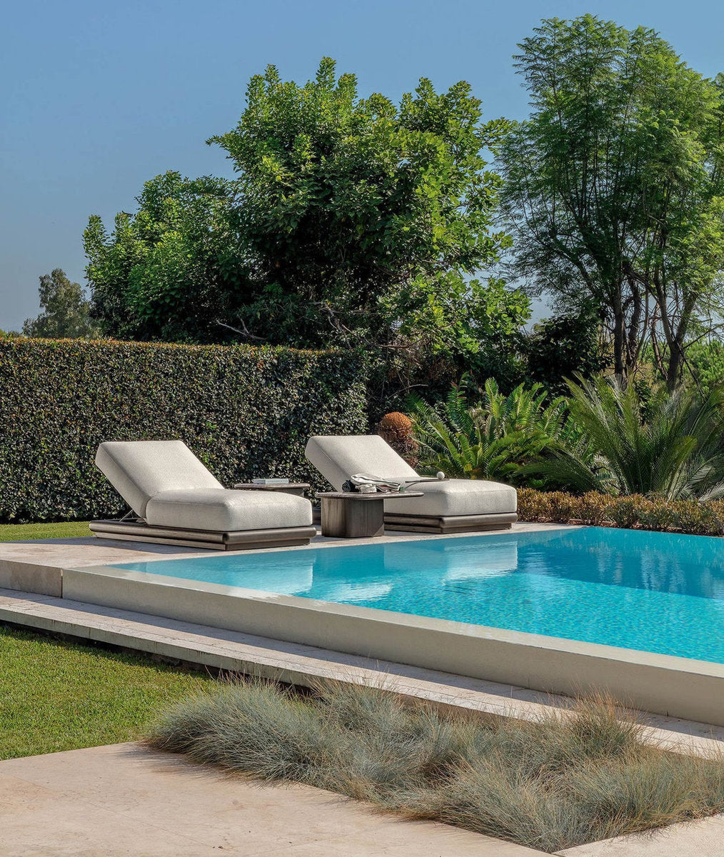 Due lettini outdoor Talenti Itaca bordo piscina con cuscini chiari e tavolino in giardino contemporaneo