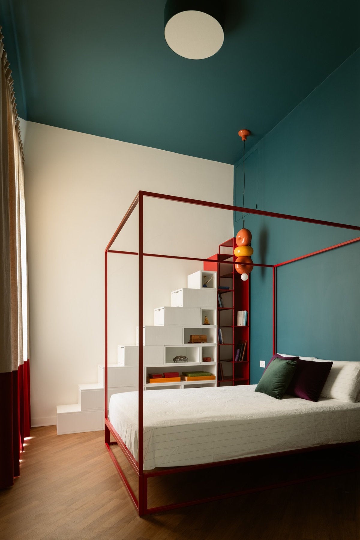 Letto Xam Asha rosso in una stanza con pareti verde e avorio con arredo contemporaneo