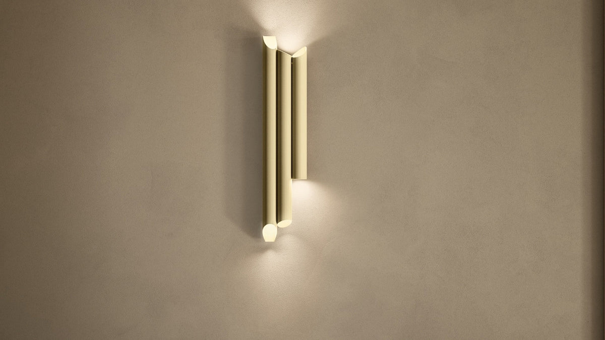 Applique LED Na-ar A3 di Masiero in ottone rigato dorato, con tre elementi verticali e luce calda verso l'alto e il basso.
