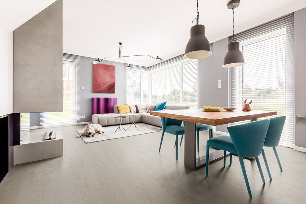 Zona pranzo con pavimento SPC Starkc Skema, finitura Porto, effetto legno neutro su base grigia
