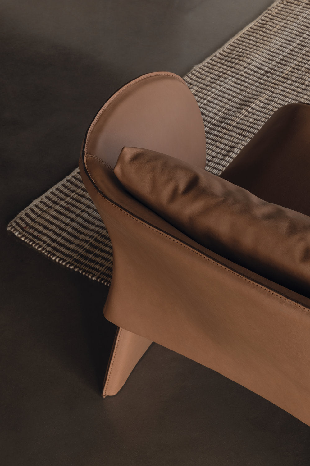 Dettaglio schienale e cuscino in pelle marrone chiaro della poltrona Knight di Cierre
