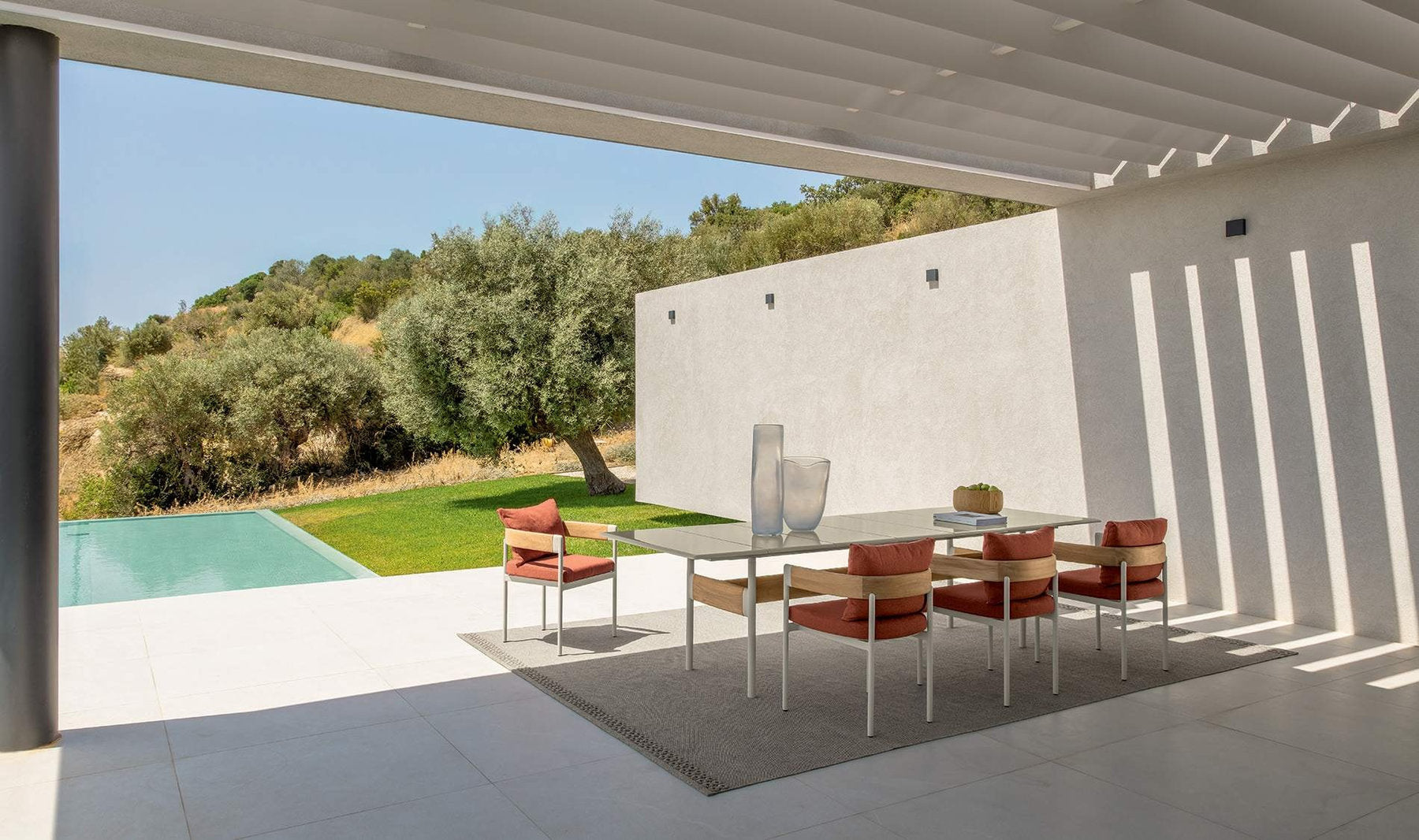 Tavolo da pranzo outdoor Flow Talenti con sedie coordinate su terrazza coperta con piscina e giardino