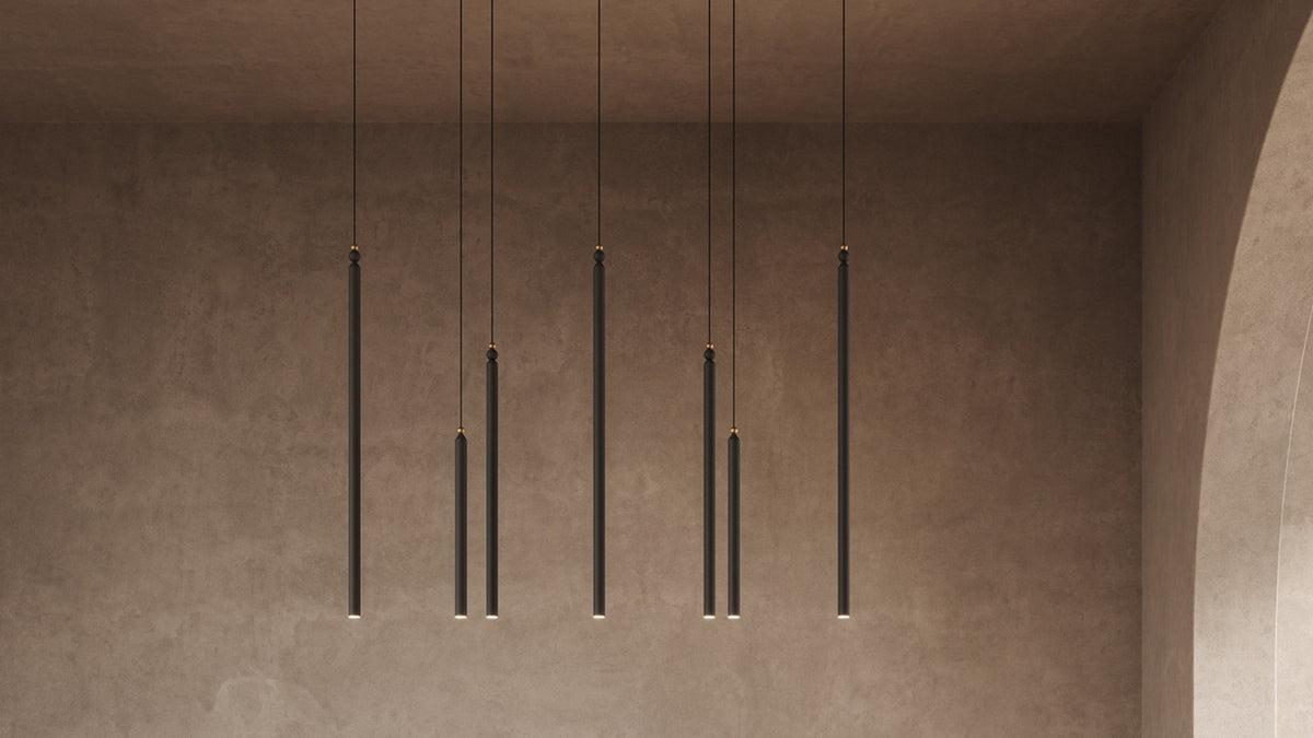 Sospensione lineare Serica C7 CB 120 di Masiero con sette elementi cilindrici LED neri disposti a diverse altezze.