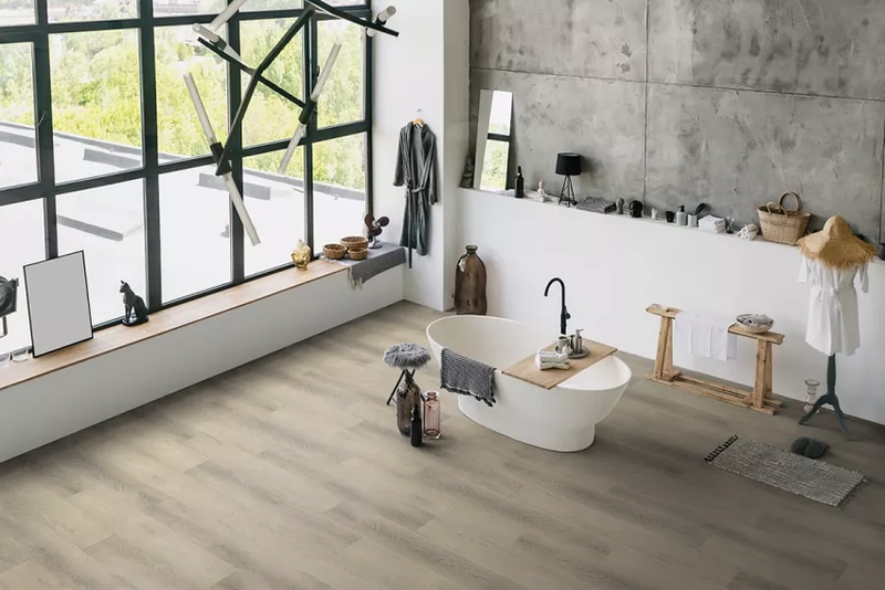 Bagno contemporaneo con vasca freestanding e pavimento SPC StarKR decoro Rovere Alcalino, posato in ambiente luminoso con pareti in cemento