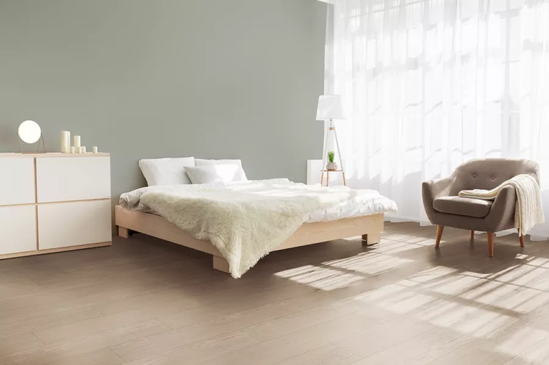 Camera da letto minimal con pavimento laminato effetto legno chiaro Skema Prestige L Alpaca Oak, ideale per interni caldi e rilassanti
