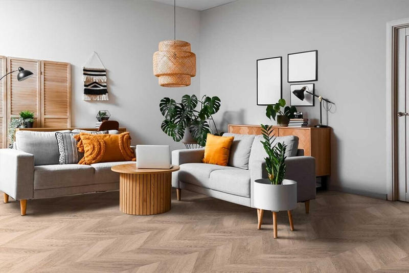 Zona giorno luminosa con pavimento in laminato effetto rovere naturale a spina ungherese Skema