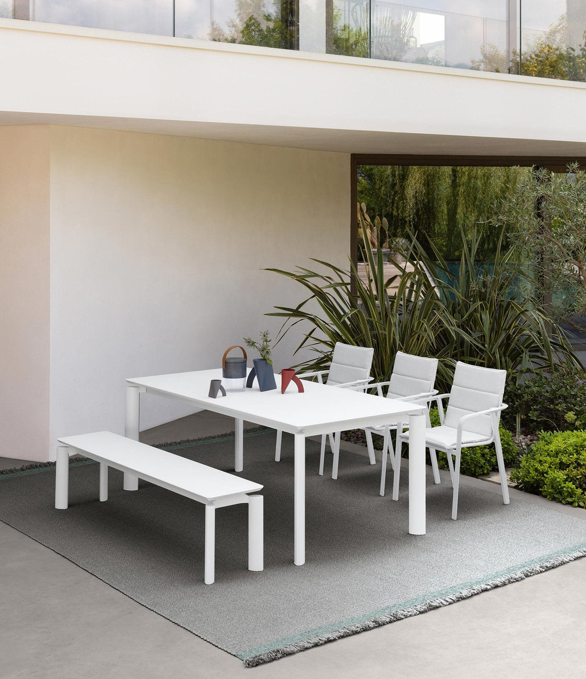 Zona pranzo outdoor Milo Talenti con tavolo bianco, panca e poltrone in alluminio per terrazza