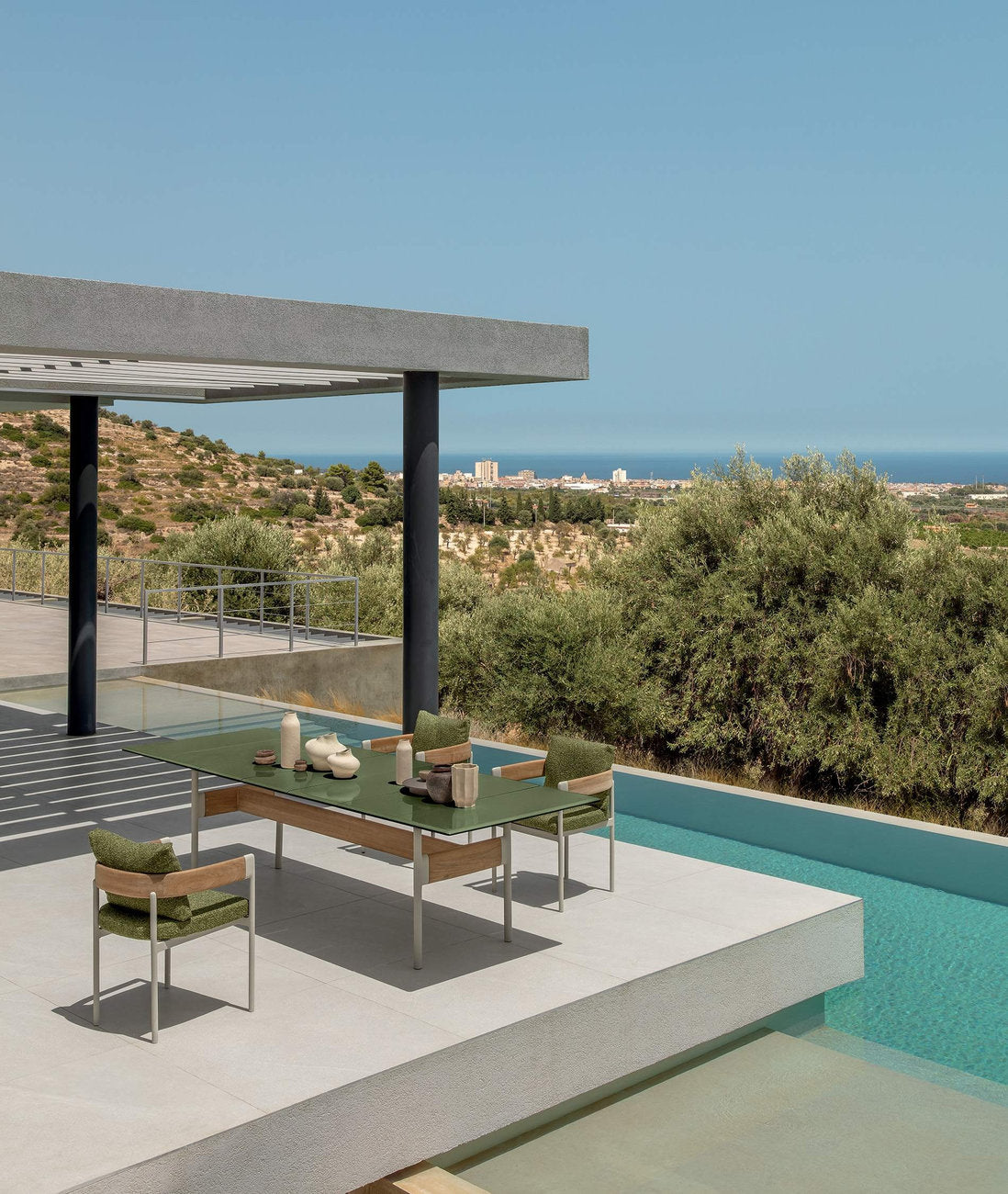 Tavolo da esterno Flow Talenti con sedie coordinate su terrazza panoramica con piscina e vista paesaggio