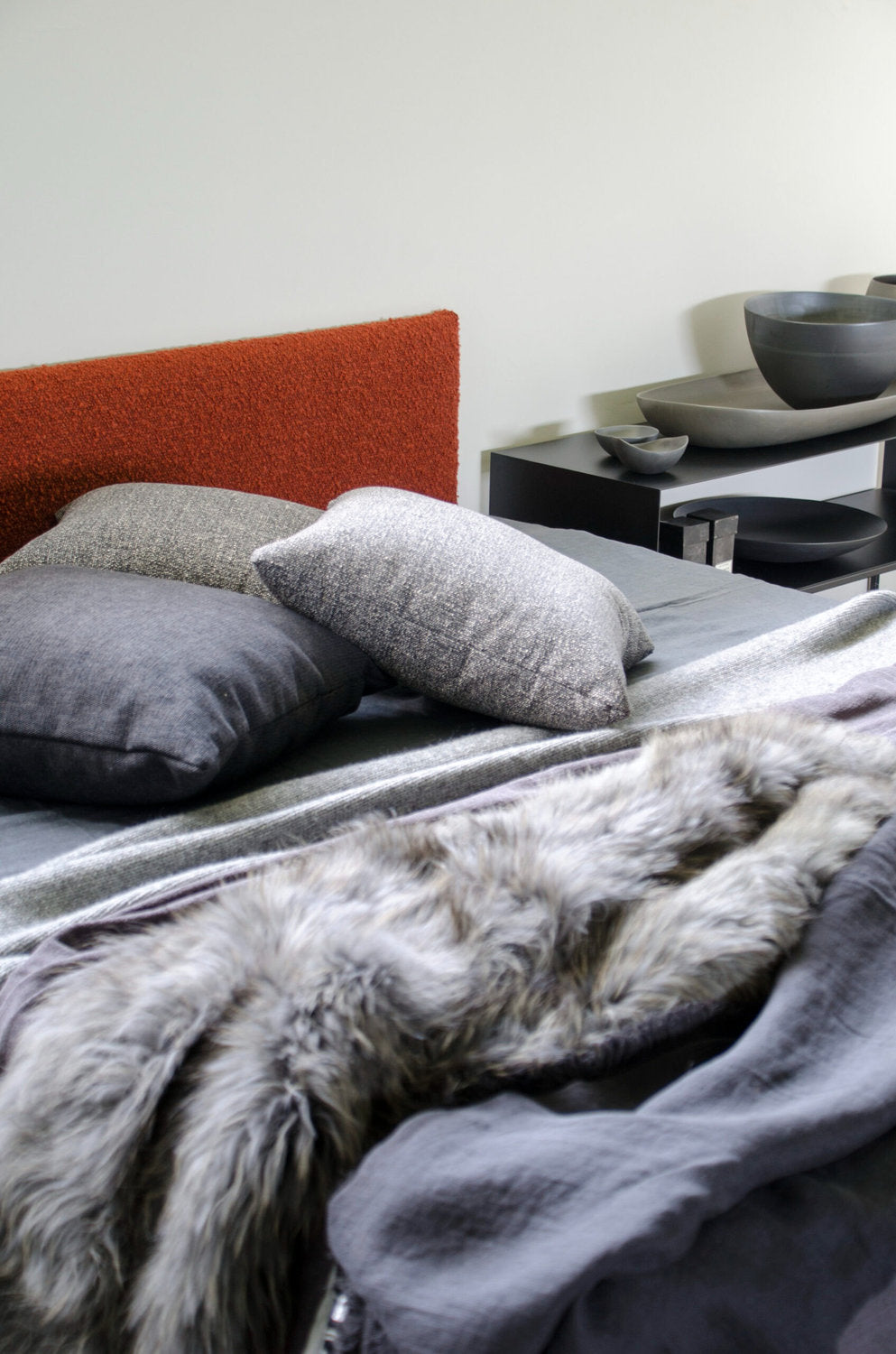 Testata letto a parete di Xam in tessuto bouclé arancio su letto moderno in colori grigi