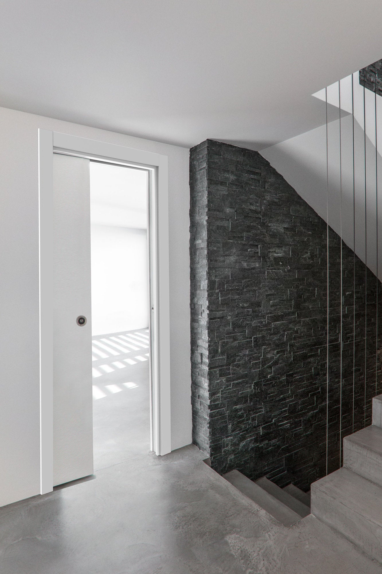 Porta scorrevole interno muro VSI Viva in finitura bianca, corridoio con cassonetto