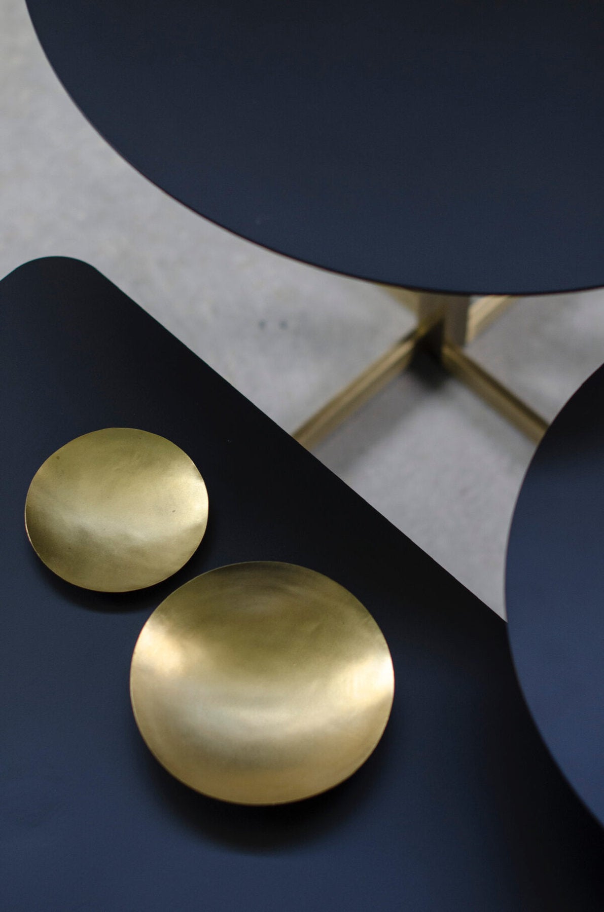 Piano nero in ferro del tavolino Xo Brass con coppette decorative in ottone su superficie 