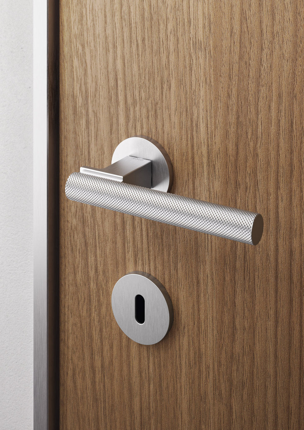 Dettaglio maniglia Ento Stelo satinata su porta in legno con bocchetta coordinata