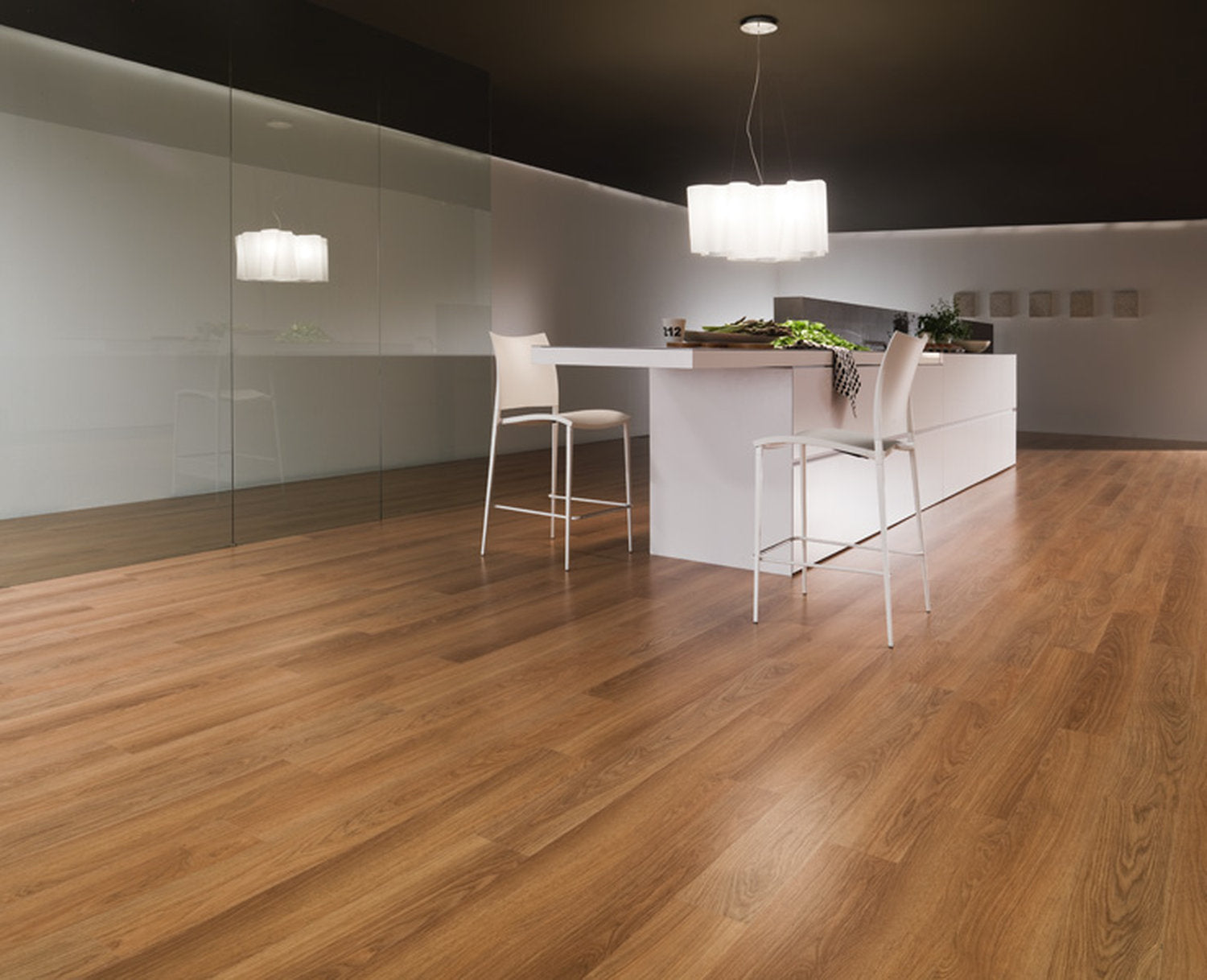 Cucina con isola centrale e pavimento in laminato effetto legno caldo, modello Skema Facile+ in posa regolare
