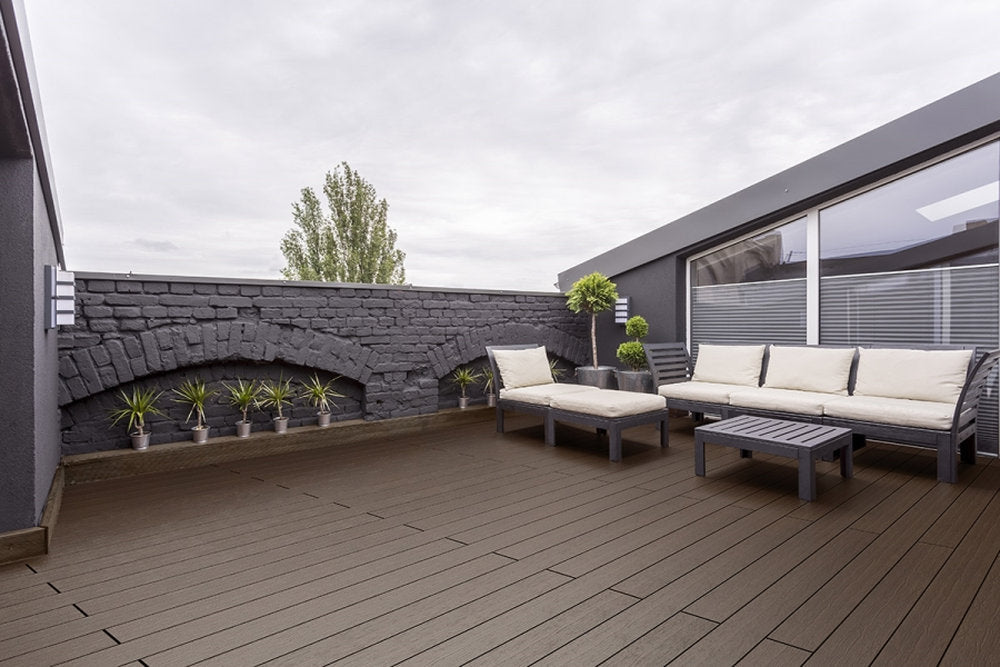 Pavimento Marina Pacto Skema su terrazza urbana con arredi lounge e pareti in pietra scura