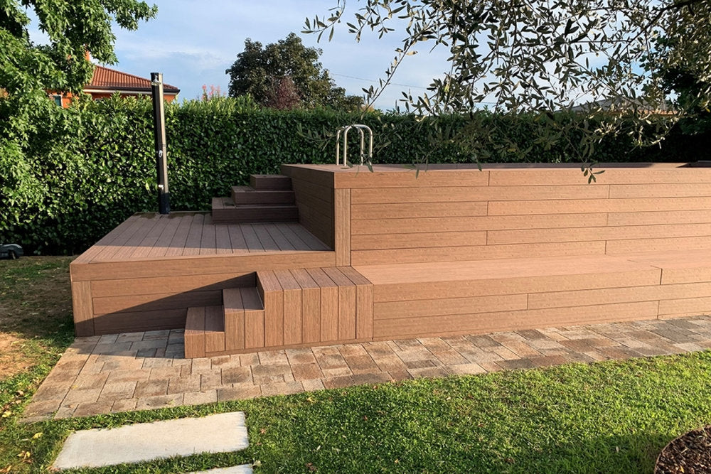 Rivestimento WPC Marina Pacto Skema in finitura Panarea attorno a piscina rialzata con gradoni integrati