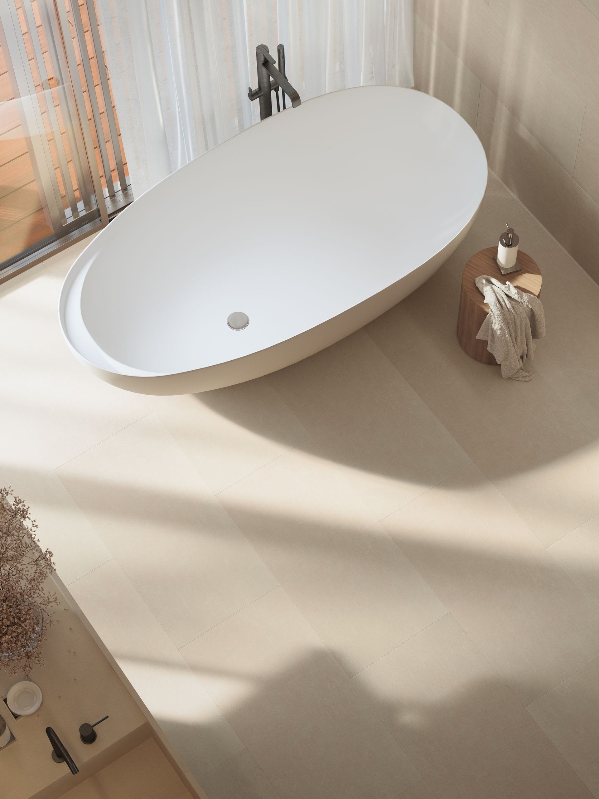Vista dall’alto di una vasca da bagno ovale posata su pavimento SPC Skema StarKD finitura Cardiff, in ambiente luminoso con luce naturale.