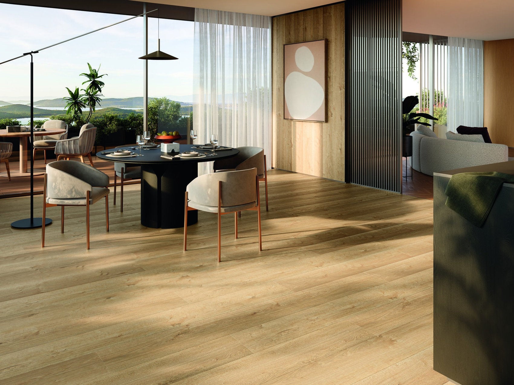 Sala da pranzo moderna con pavimento laminato effetto rovere chiaro, tavolo rotondo nero e sedie imbottite.