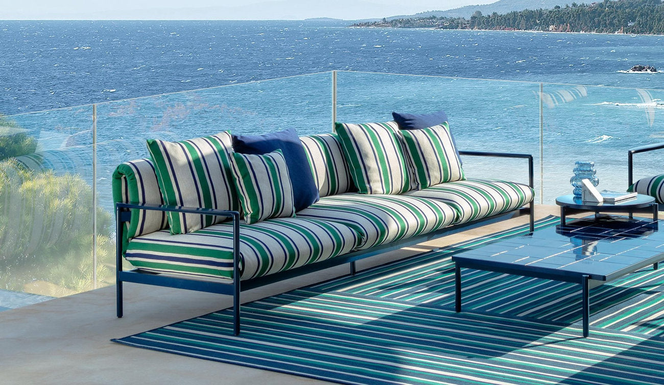 Divano tre posti per esterni Nalu Talenti con a righe verdi e bianche su terrazza al mare