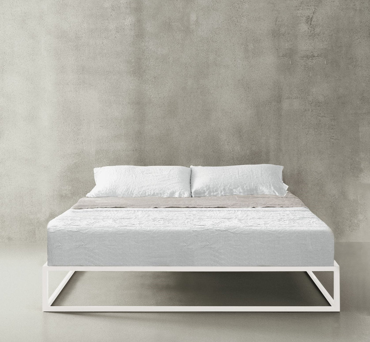 Letto Asha Basic con telaio bianco e rivestimento letto grigio chiaro e parete neutra 