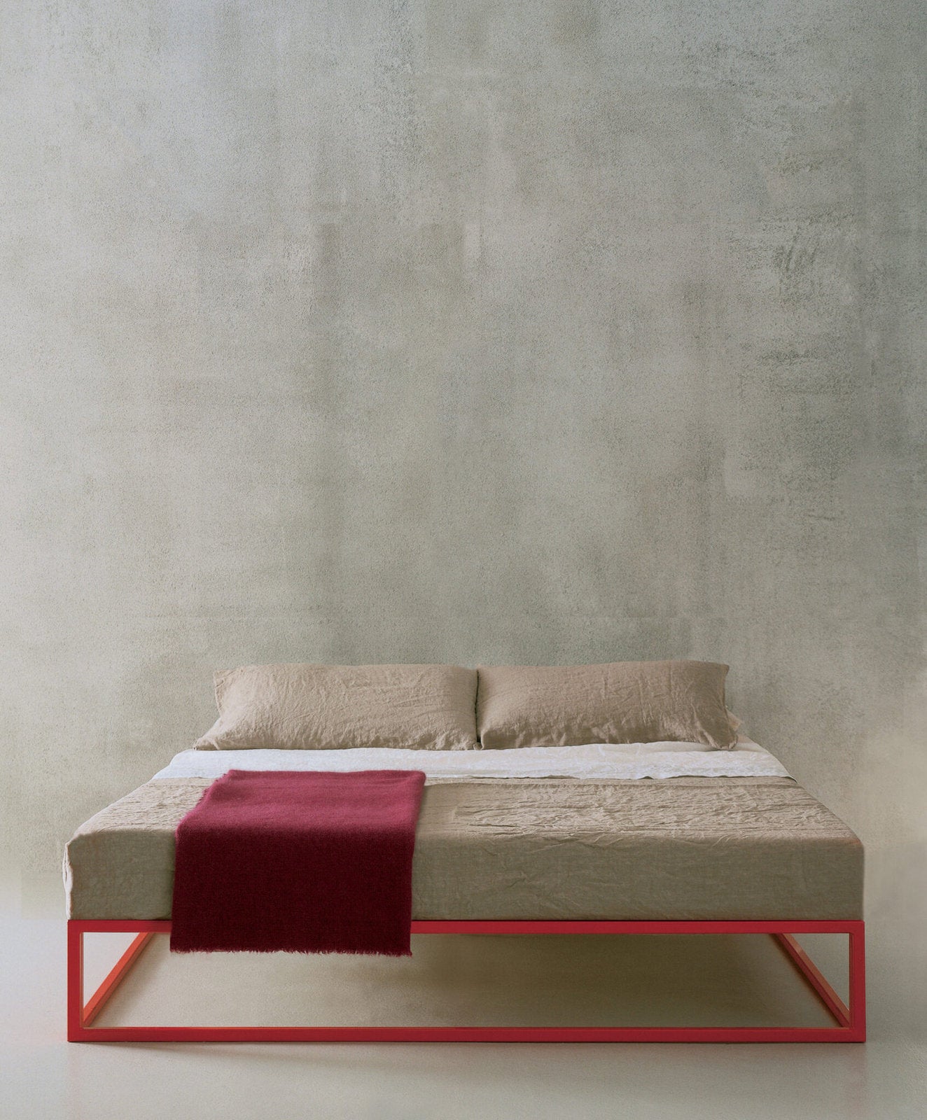 Letto Asha Basic con struttura rossa in acciaio, biancheria beige e coperta bordeaux 