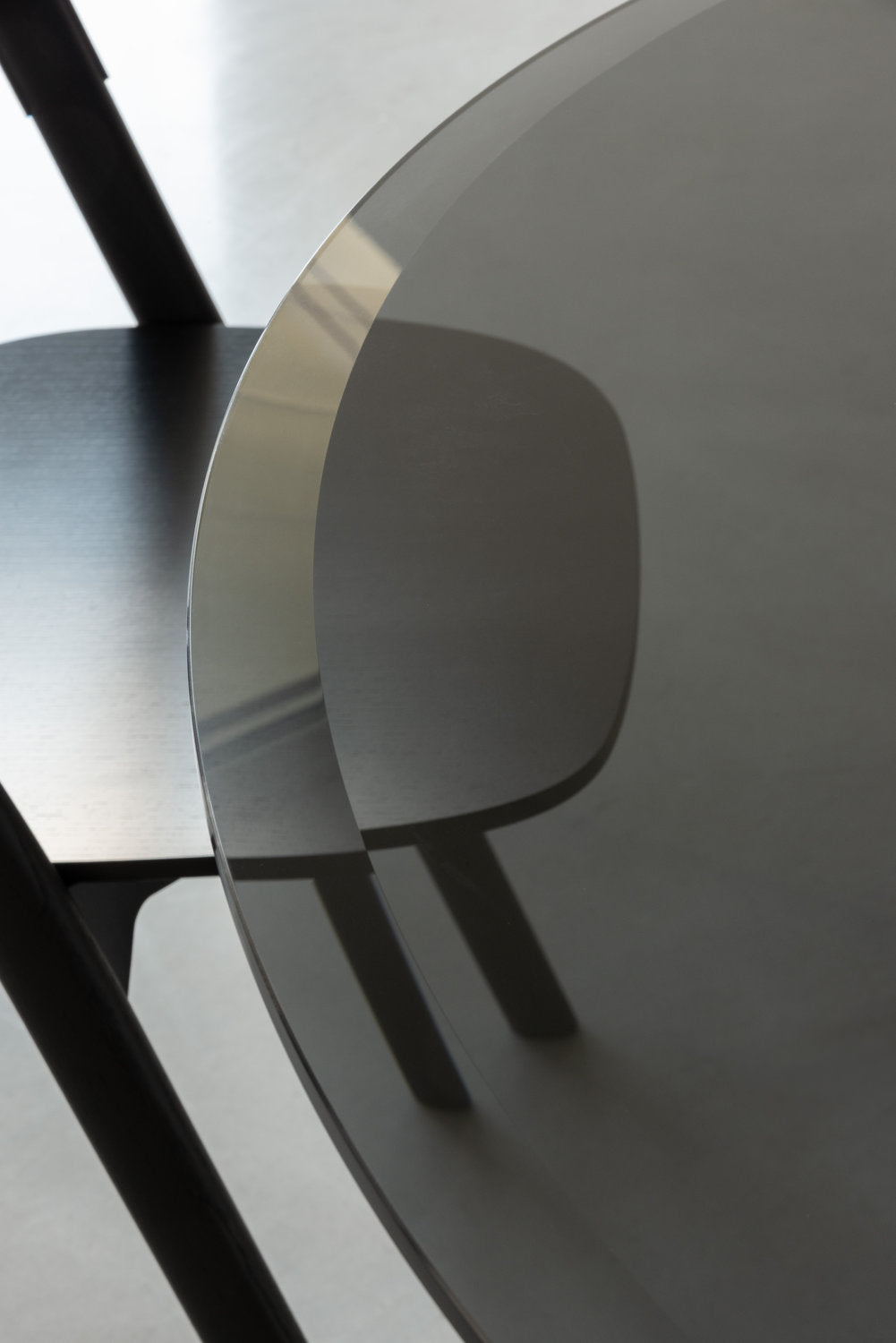 Dettaglio bordo del piano in vetro temperato fumé del tavolo rotondo Ancora Magis 