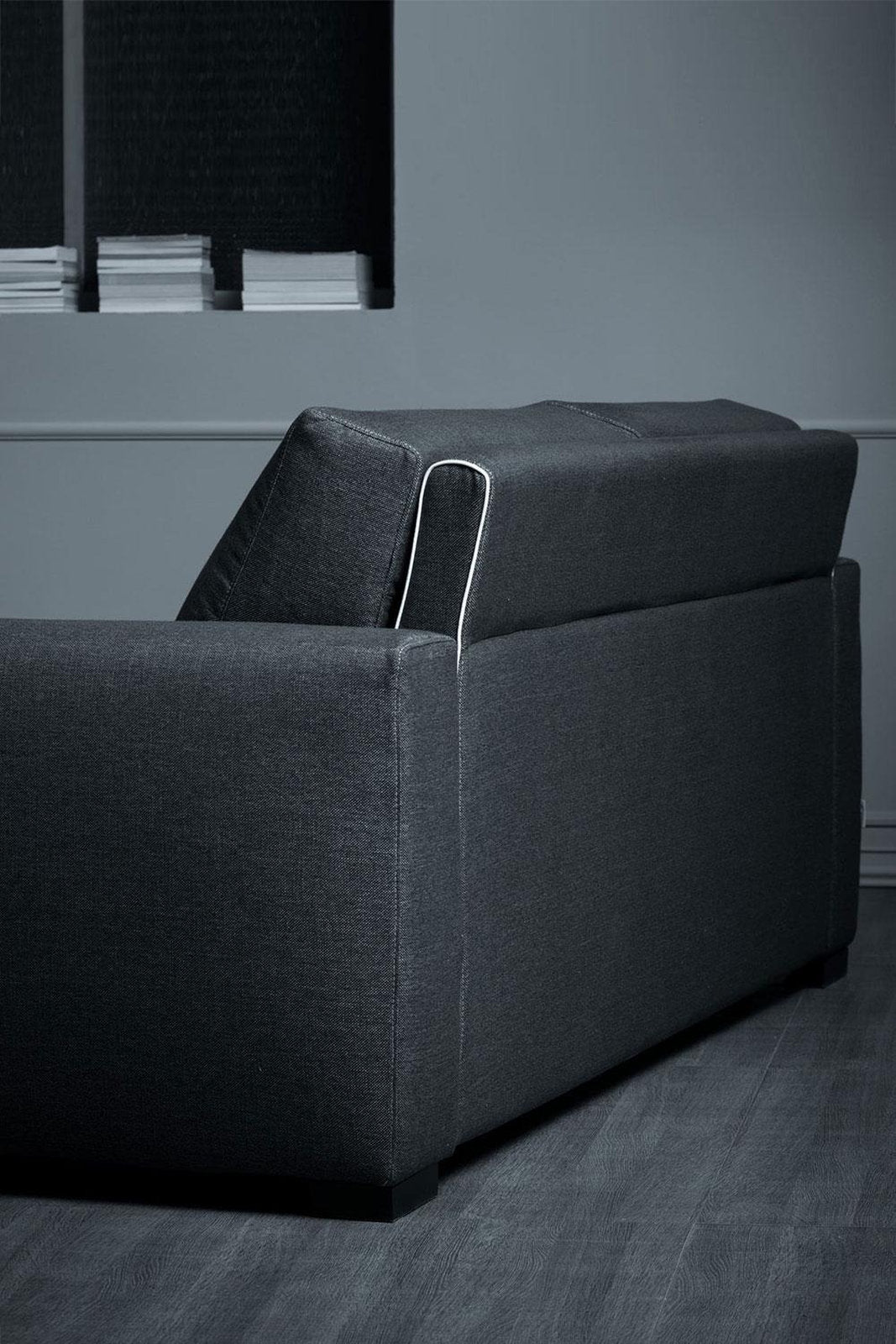Retro del divano letto Magnum in tessuto grigio, con schienali inclinati e profilo a contrasto 