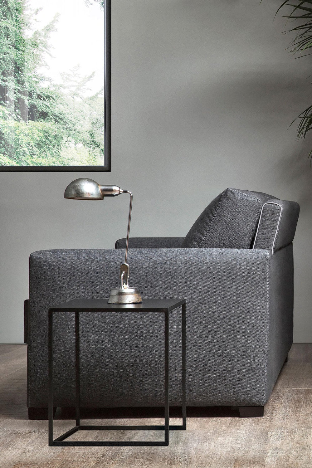 Vista laterale del divano letto Magnum in tessuto grigio con schienali inclinati e bracciolo lineare