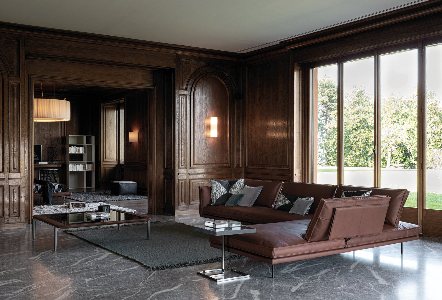 Divano modulare Cierre imbottiti in pelle marrone in soggiorno classico con boiserie