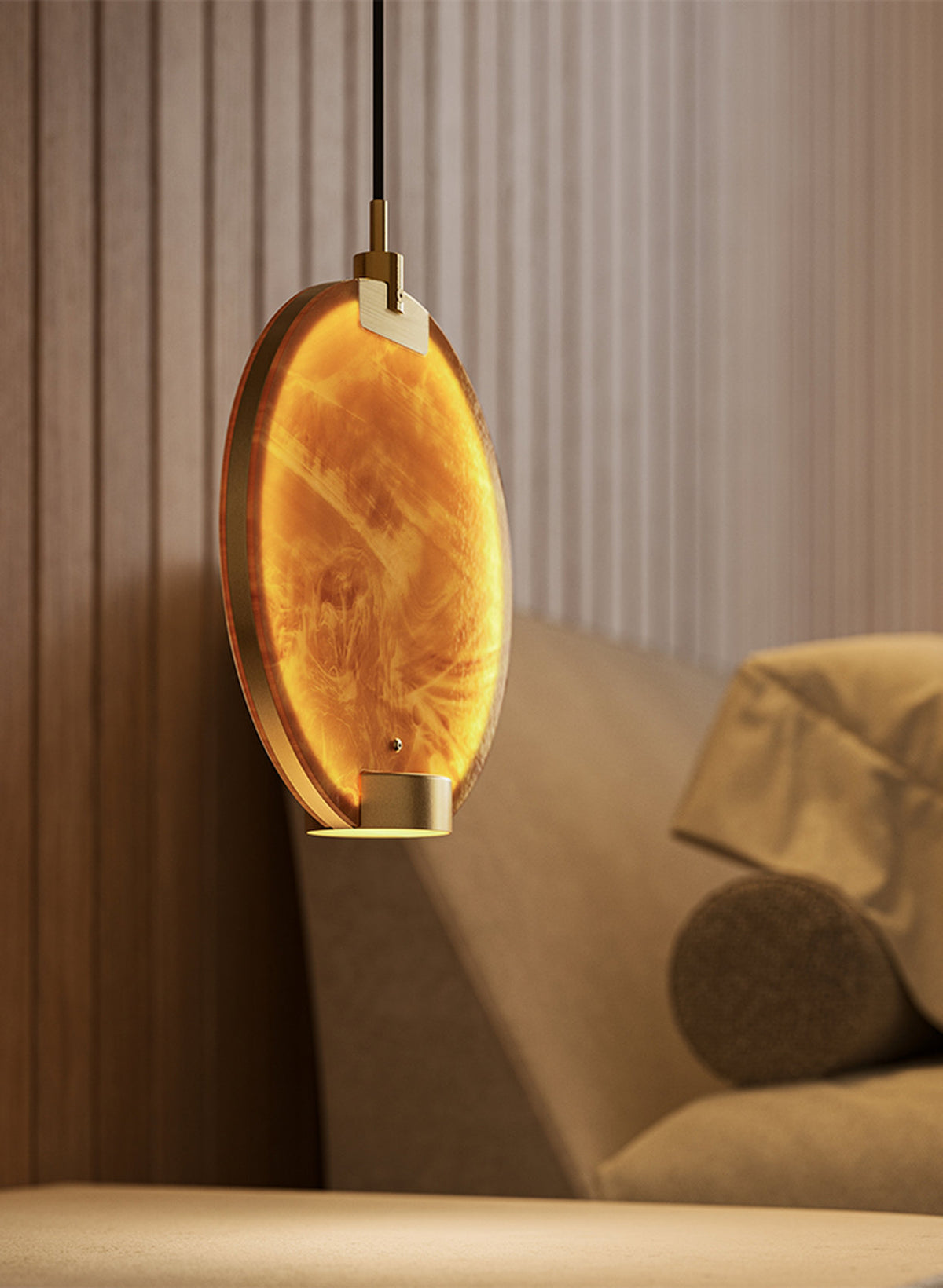 Dettaglio della lampada a sospensione Horo di Masiero, con disco luminoso in vetro ambrato e supporti metallici dorati.