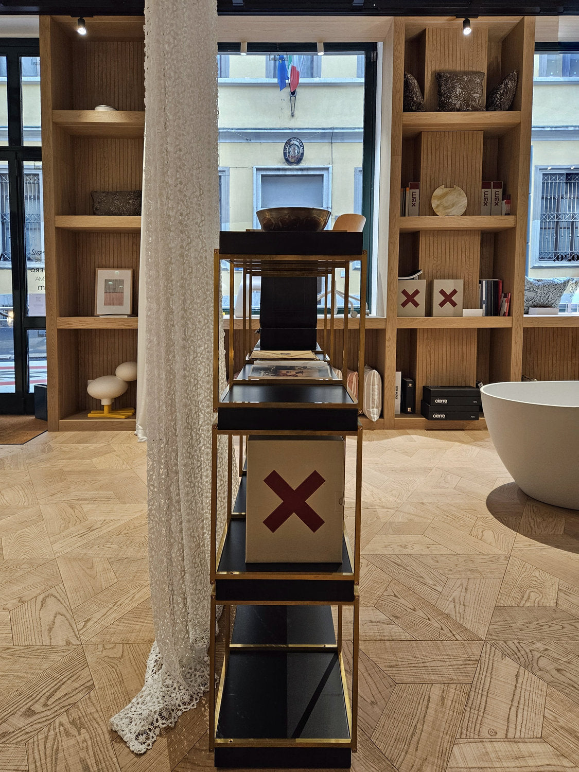 Sistema libreria New York Xam allestimento verticale showroom Atlantico ottone e mensole nere