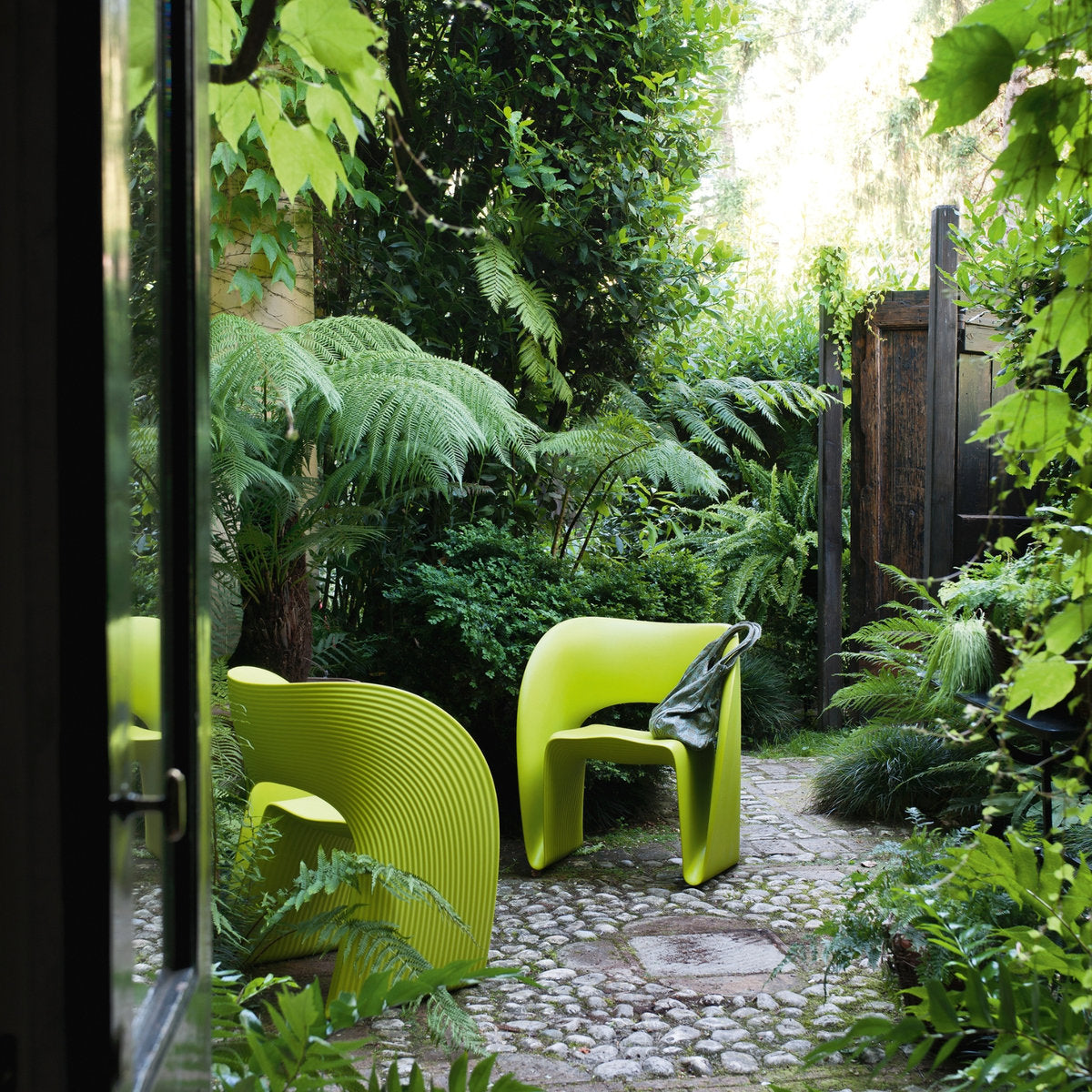 Due poltroncine Raviolo di Magis verdi in contesto di giardino domestico