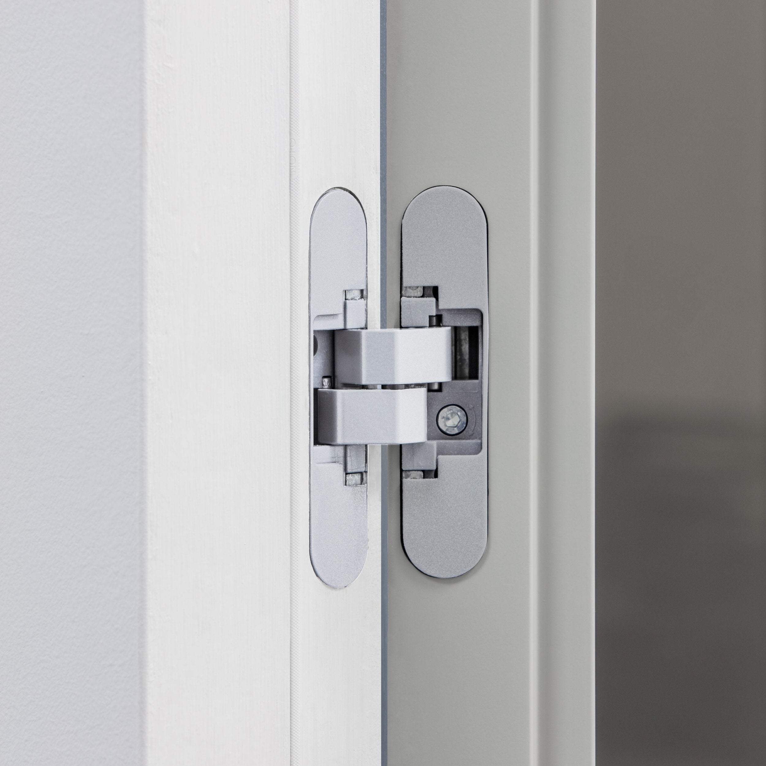 Cerniera invisibile regolabile su porta Viva con telaio filomuro complanare, dettaglio tecnico.