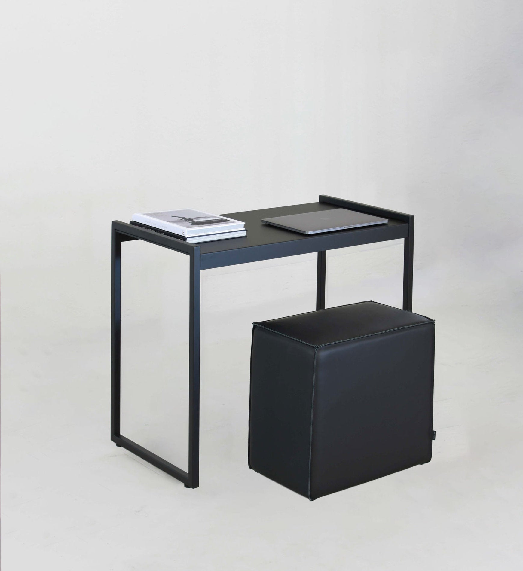 Dettaglio scrivania Vestia xam finitura antracite con piano d'appoggio in lamiera e pouf nero