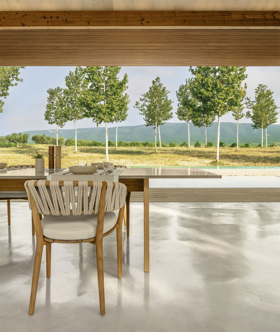 Sedia outdoor Talenti Venice in legno teak con intreccio in corda e cuscino, ambiente pranzo esterno