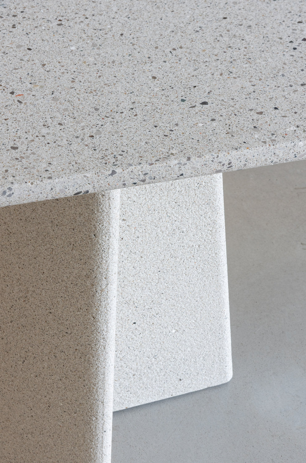 Dettaglio piano e gamba del tavolo Ancora Magis in cemento levigato con graniglia a vista