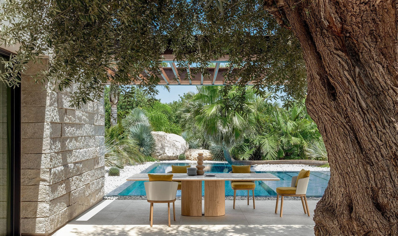 Tavolo outdoor Itaca Talenti con sedie su patio coperto affacciato su giardino e piscina